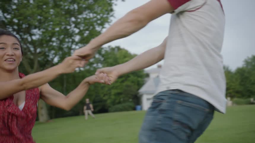 The man and woman hold hands and swing around