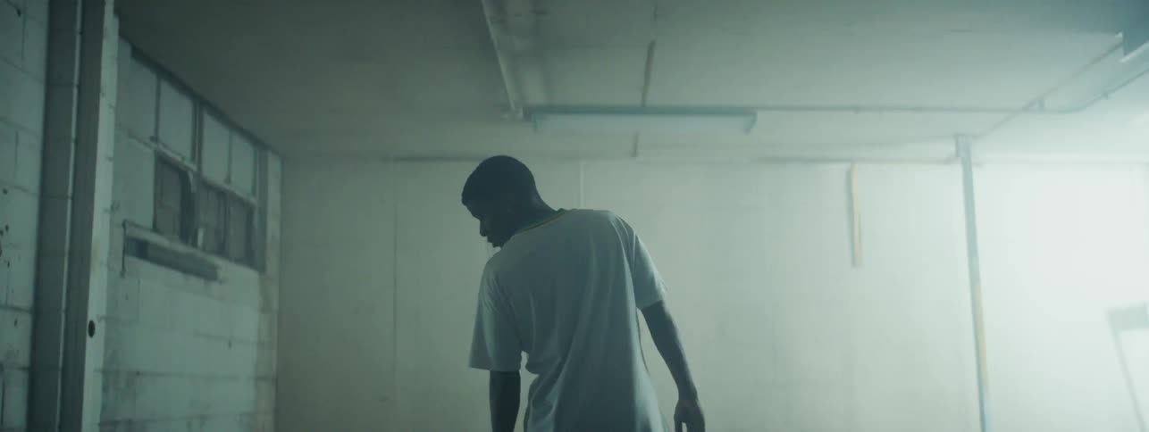 Man stands in a white room as a light flashes on and off