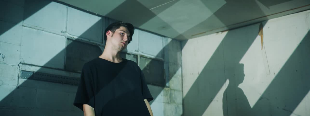 Boy stand in an empty small room pacing