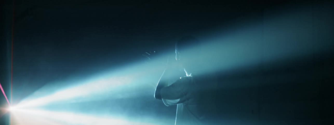 Man shields his eyes as a light flashes on him
