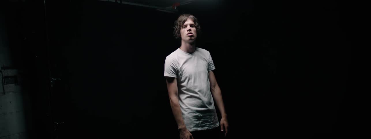 Man stands in a dark room looking up