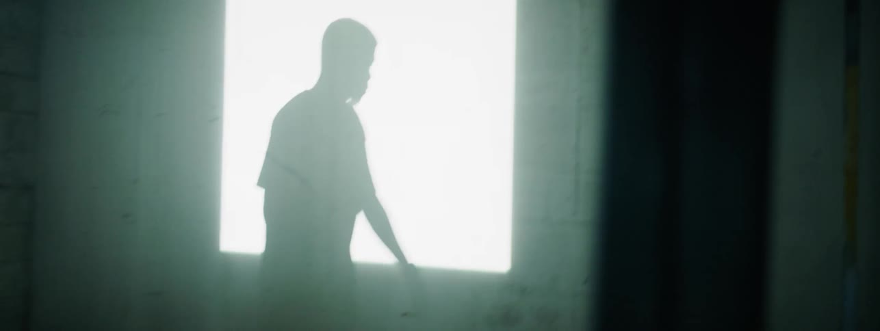The shadow of a boy is projected on the wall of a room