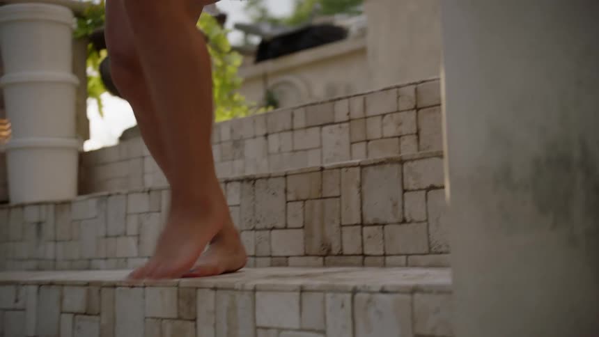 The person climbs down the stone steps