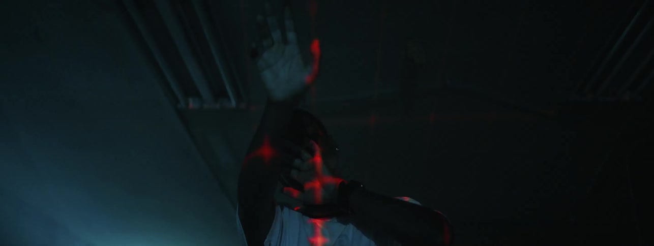 The man raises his hands in front of the red light