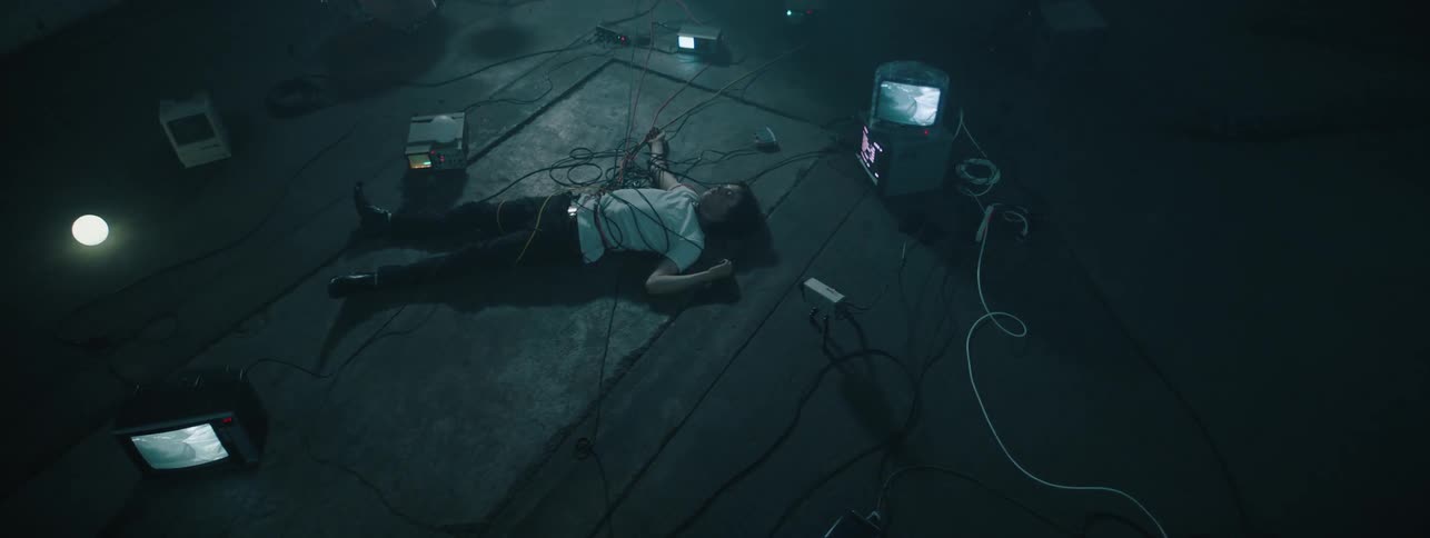 Man lays on the floor with wires wrapped around him