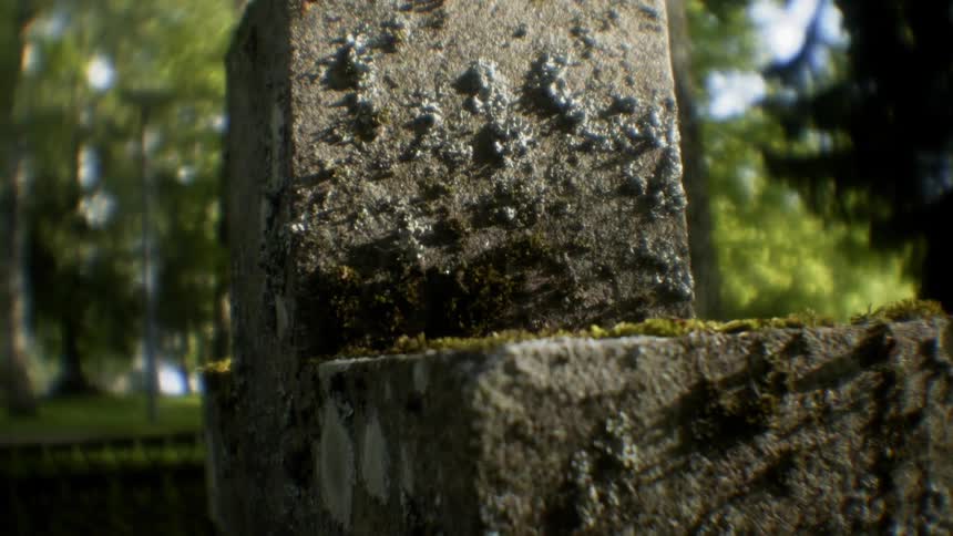 Mossy stone cross in cemetery