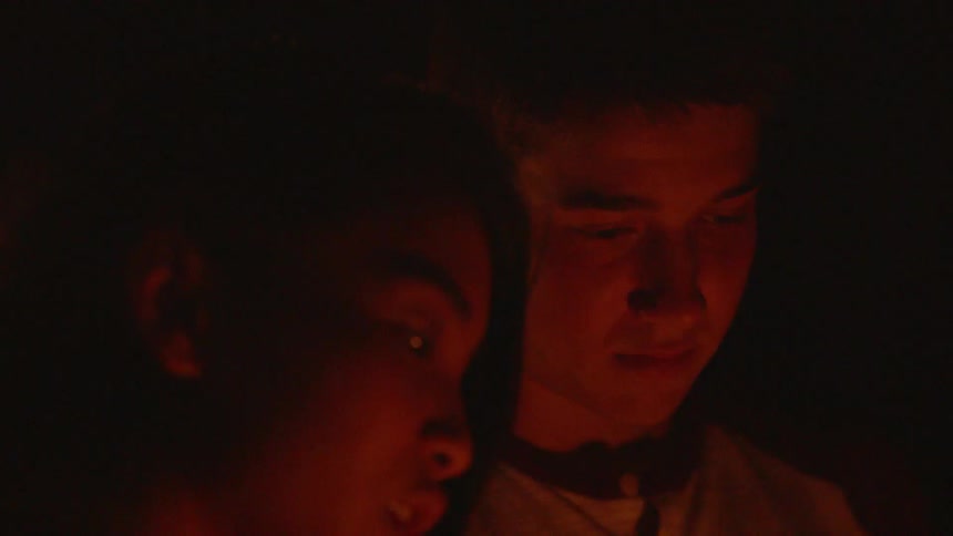 Guy and girl are lighting sparklers outside at night