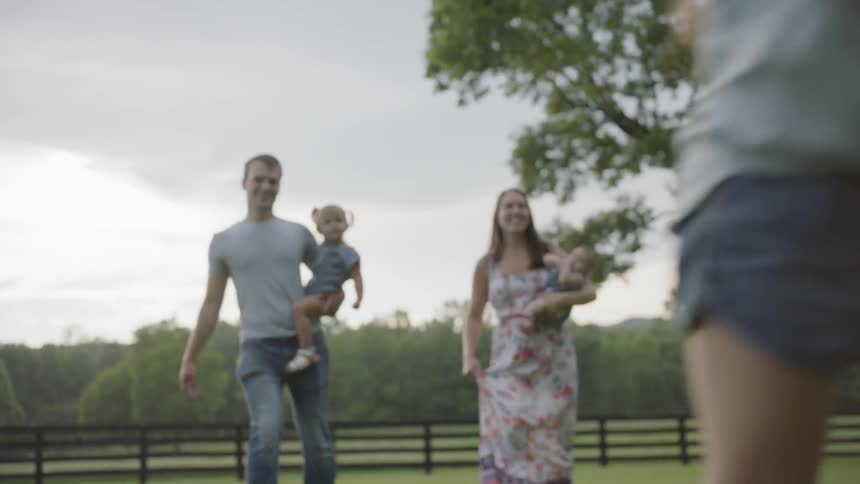 The parents carry their children as another runs ahead