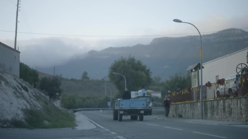 The truck drives past someone walking on the side of the road