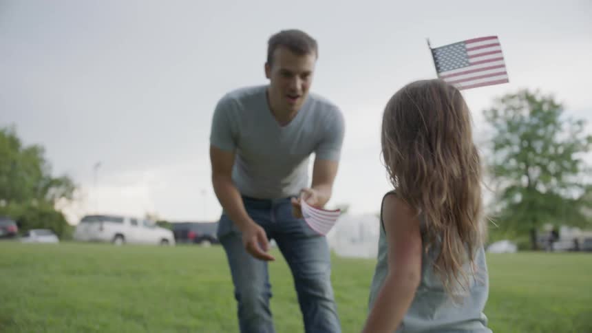 Child runs and waves a flag with a man
