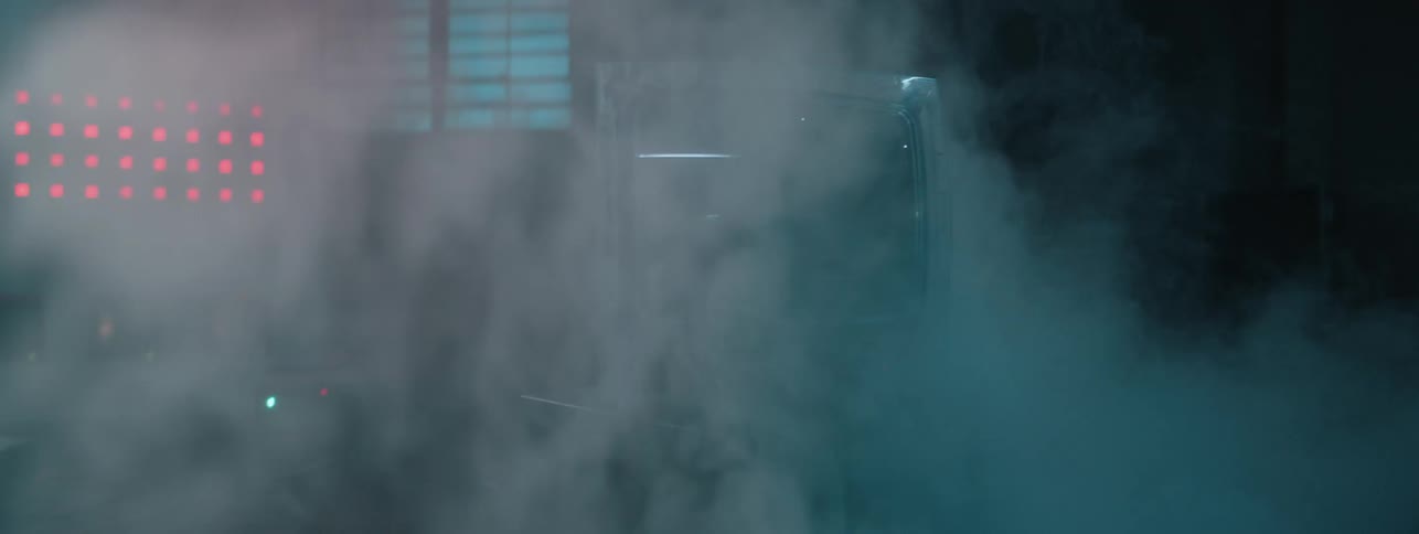 Smoke floats around a television flashing static