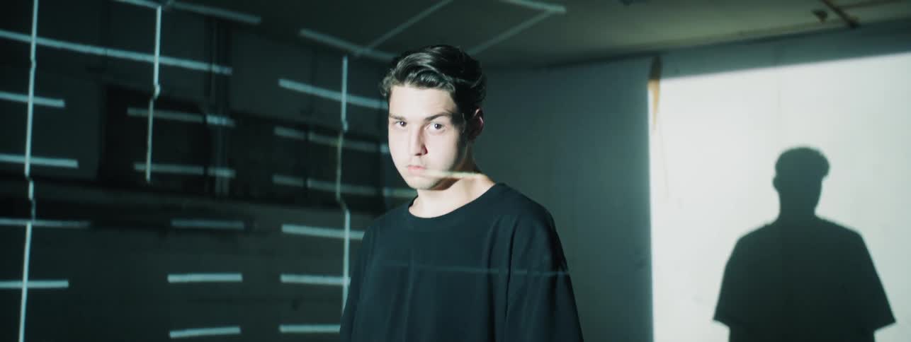 Man with laser grid in background stands staring