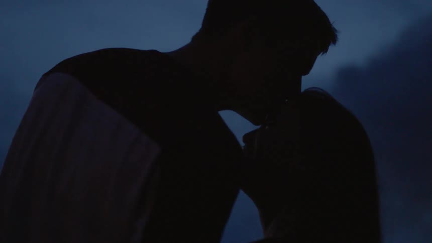 Boy kisses a girl's forehead while watching fireworks at night