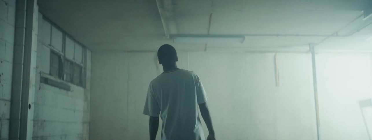 A man stands in a room looking up at the ceiling as the lights flash off and on