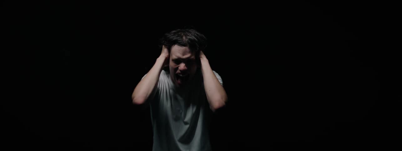 The man is doing screaming with his hands on his head