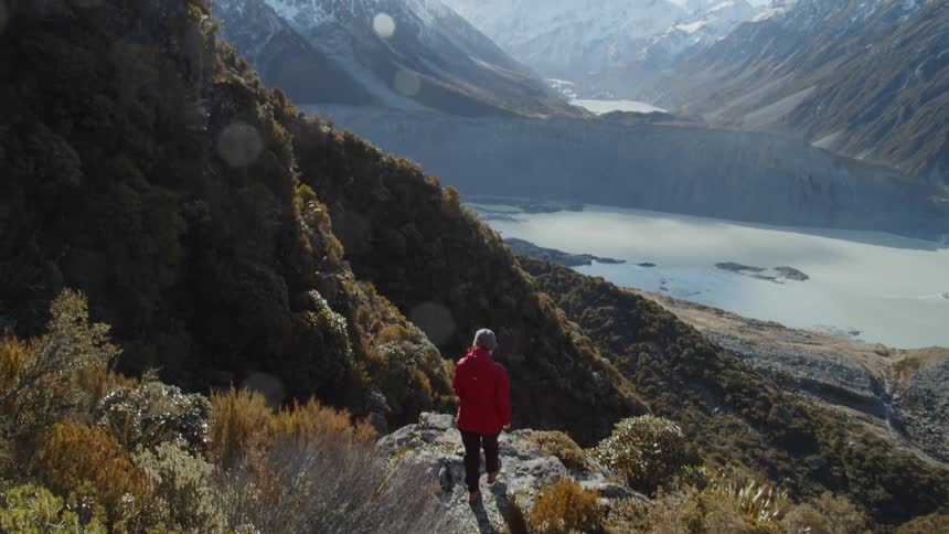 The woman is hiking down the mountain