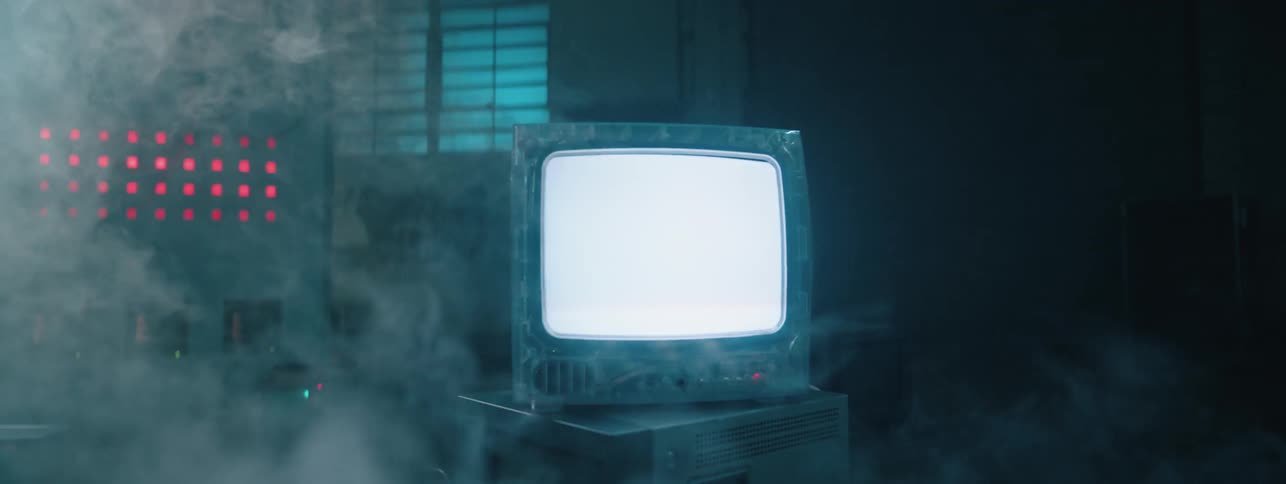 The television is flickering in the foggy room