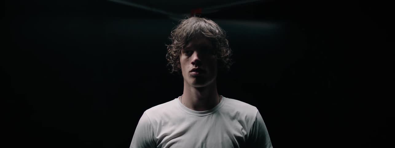 Man is standing still in dark room