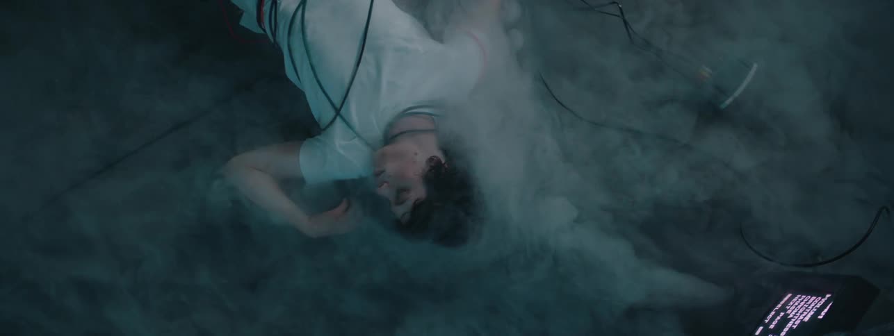 The man is laying on the ground as fog covers him