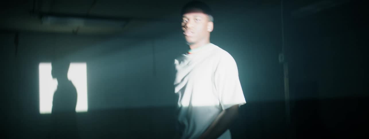 Lights flash while a man dances in a dark room