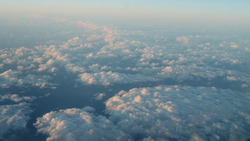 Sunlight shines down on clouds over the landscape