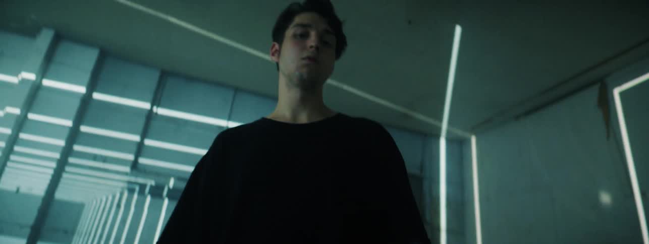 The man stands in the room with flashing lights looking around