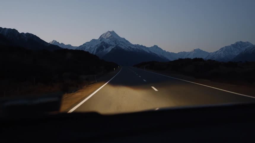Light shines on a country road at night