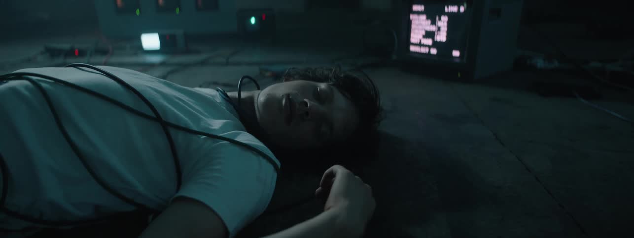 Man lays on the floor with wires wrapped around him