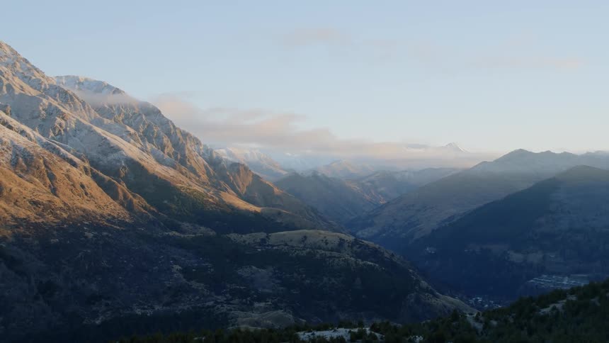 Clouds are drifting over a mountain range in daylight