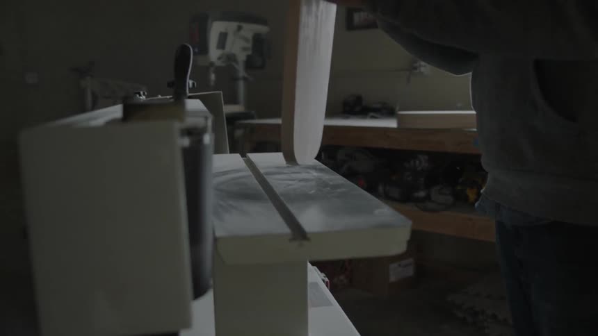 Man sanding edges of a wooden board