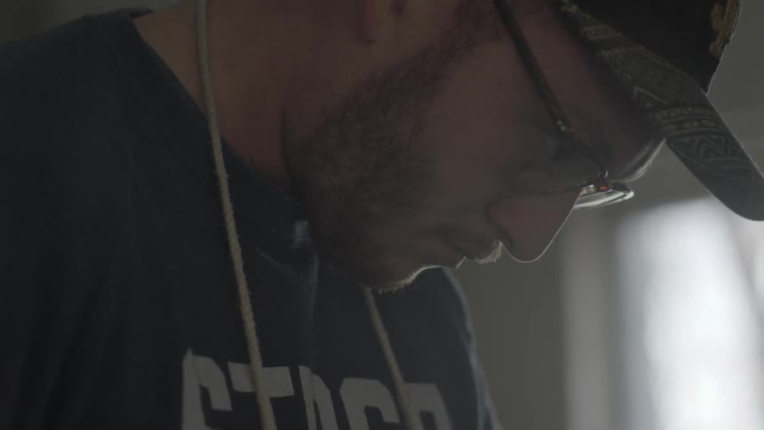 Man in glasses looking down at his task