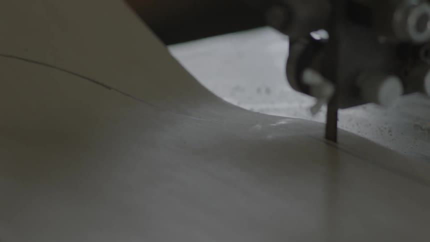 A man cuts a board with a stationary machine