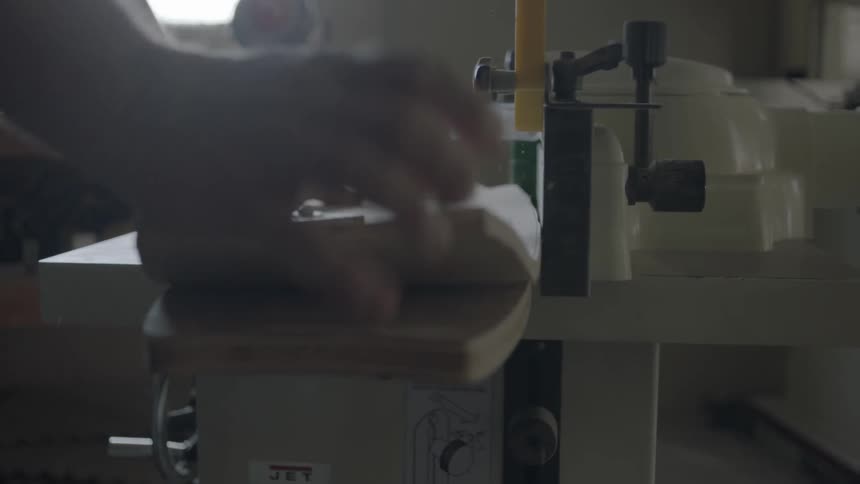A man runs two boards through a router