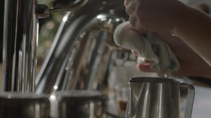 Barista wiping the milk steamer stem