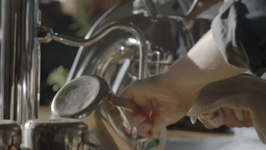 A barista drying a pitcher