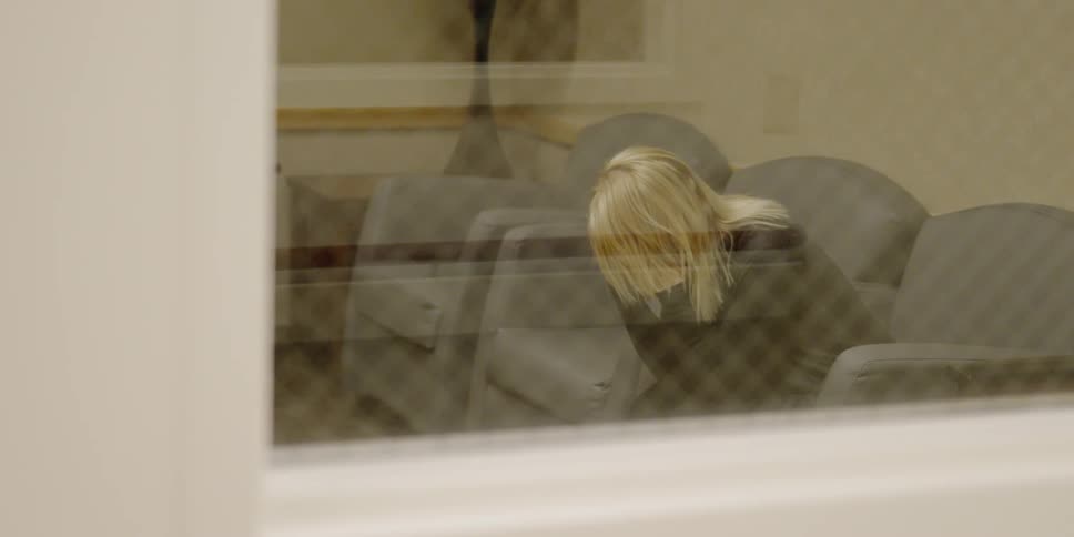 Woman sitting in a waiting area holding her head in her hands