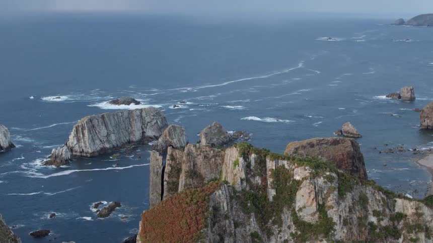 A calm sea with waves moving around rocky islands