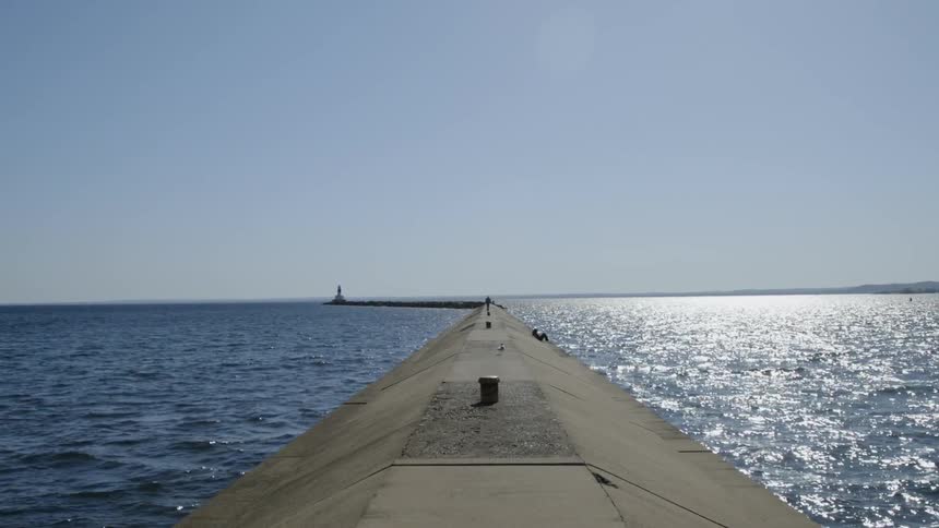 A calm sea moving around a long pier