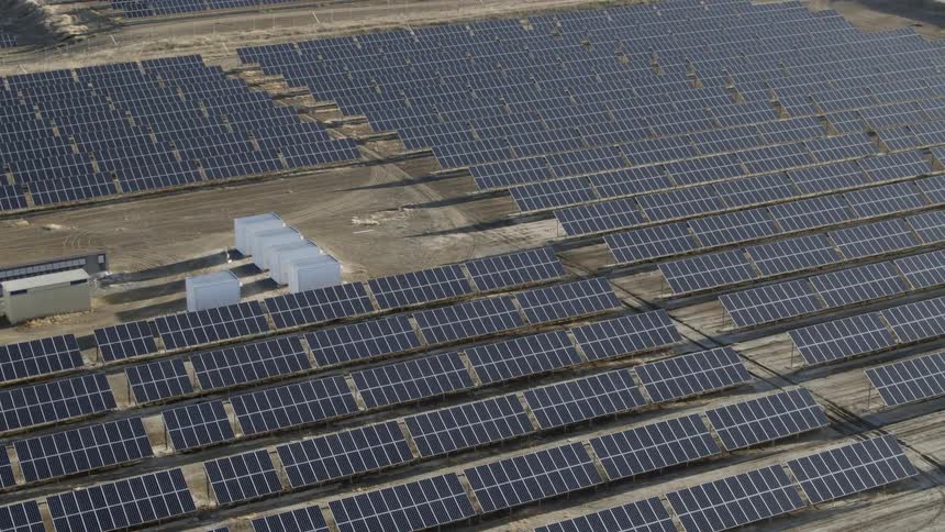 Pan over solar panels in a field