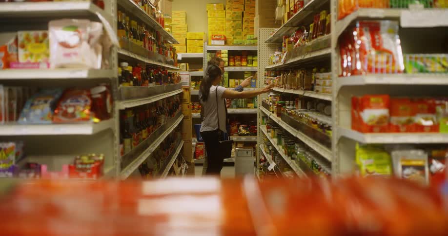A grocery store employee helps a woman with her shopping