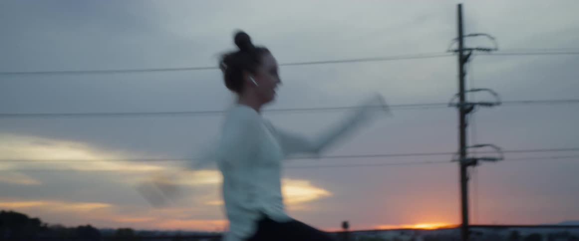 A woman dances on the building rooftop