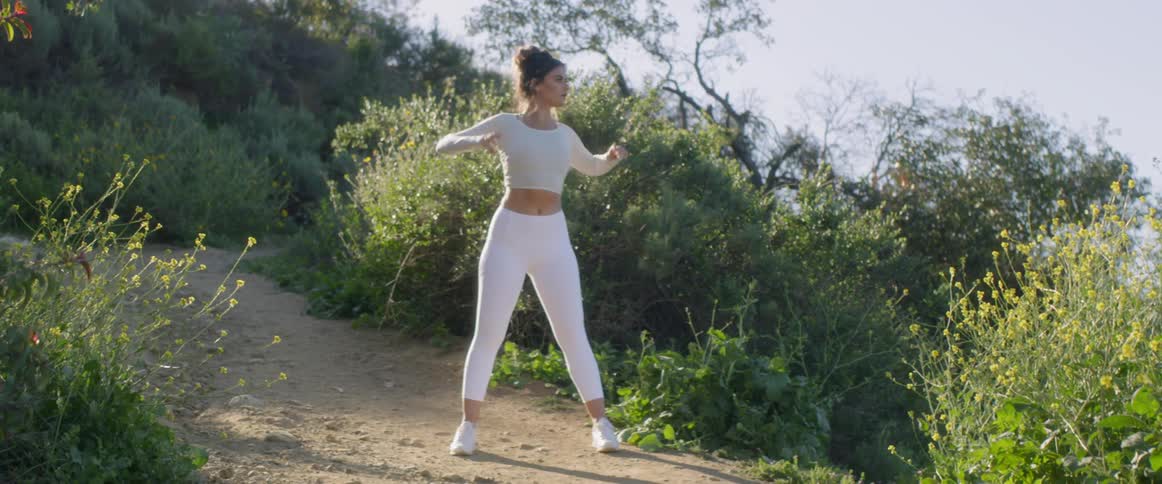 Woman stretching outdoors on a bright day