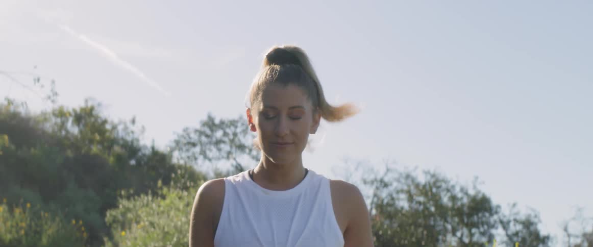 A woman with a ponytail jogs in the light of sunrise