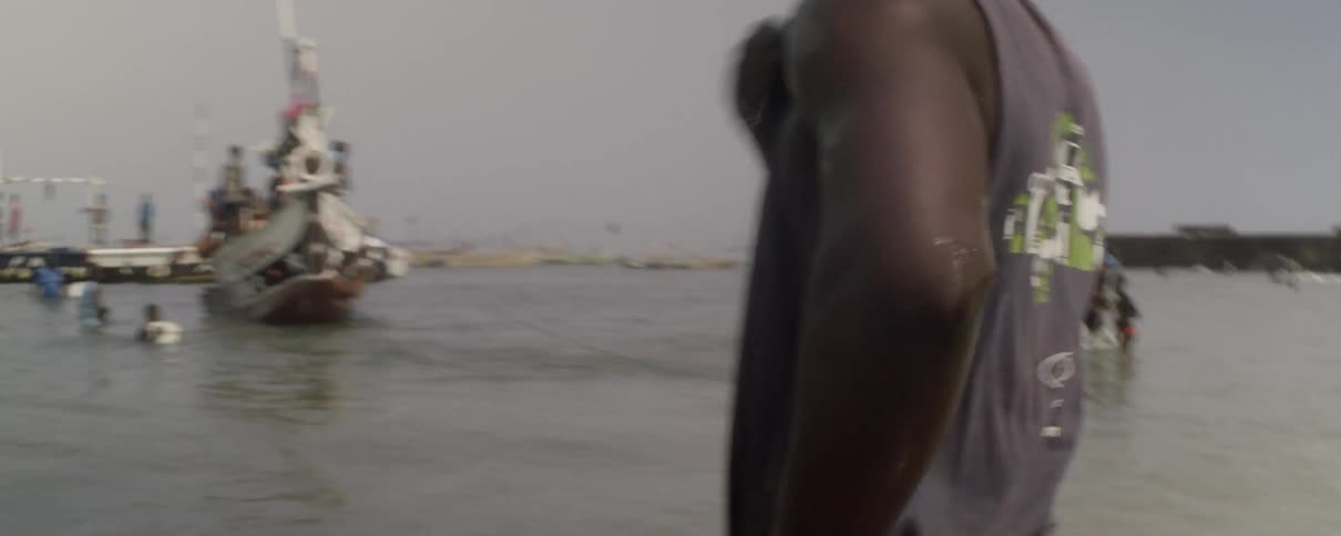A man walks into the ocean and wipes water from his face