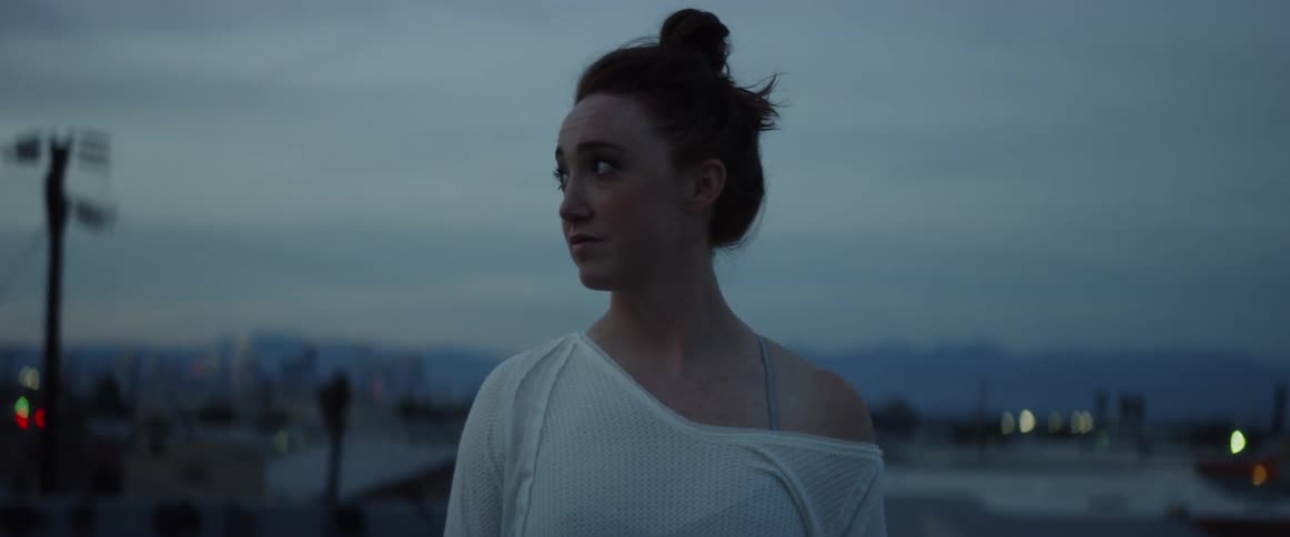 A woman looks to the right and begins to look uneasy