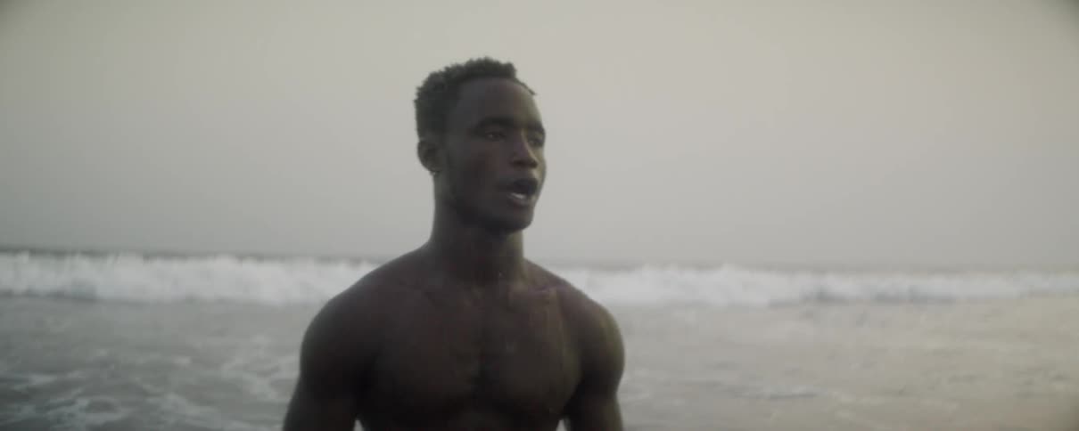 Man walking through waves on the beach
