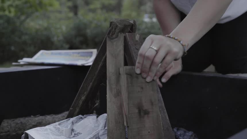 A woman sets up a small campfire