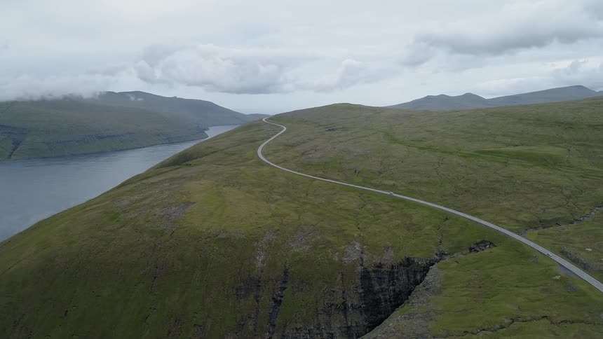 A dirt road on a hill next to a large river