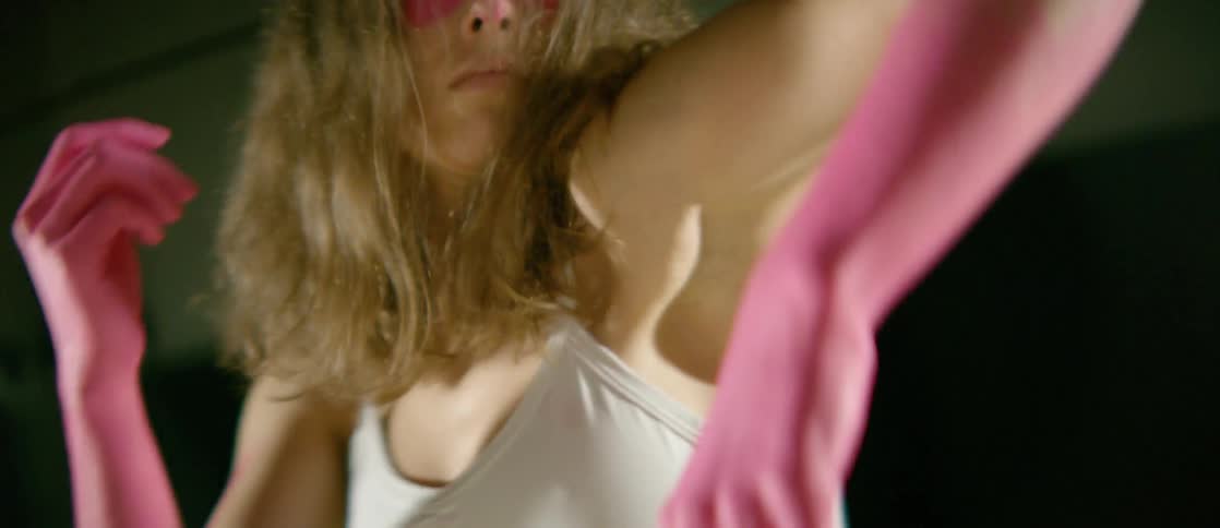 A woman dancing with pink gloves on