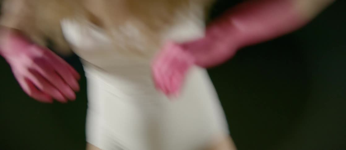 Woman with pink dyed hands swings her arms angrily